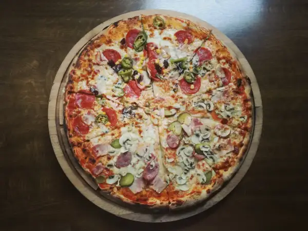 Apetyczna pizza z różnymi dodatkami. Zastanawiasz się, ile kalorii ma kawałek pizzy? Ta wygląda na sycącą!