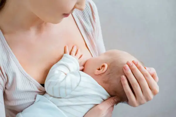 Matka karmi piersią dziecko. To naturalny proces, który wspiera art. 187 Kodeksu pracy, chroniąc prawo do przerw na karmienie.