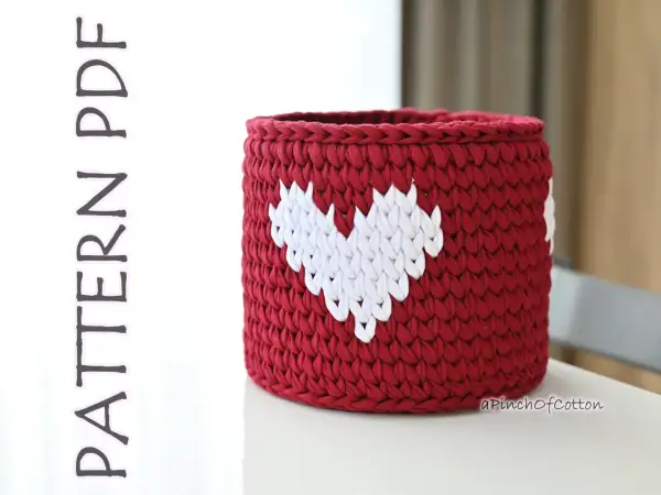 Cestino uncinetto rosso con cuori bianchi, perfetto per decorare la casa o come idea regalo.