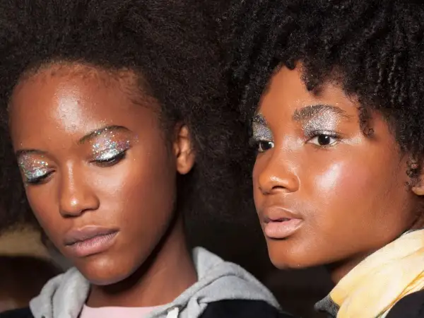 Due ragazze con un trucco scintillante sugli occhi, perfetto per un look da 18 anni. Glitter argentei e colorati illuminano le palpebre.