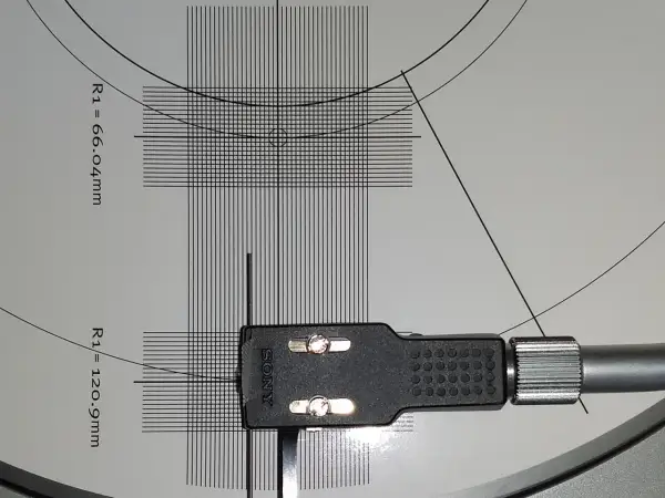 Precyzyjna kalibracja wkładki gramofonowej Sony na szablonie z liniami i wymiarami.