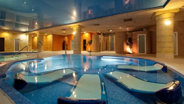 Piscina de hidromasaje con tumbonas integradas, ideal para relajantes sesiones de spa.
