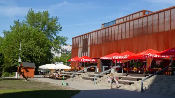 Kraków Klub Studio z czerwonymi parasolami Coca-Cola i schodami prowadzącymi do wejścia.