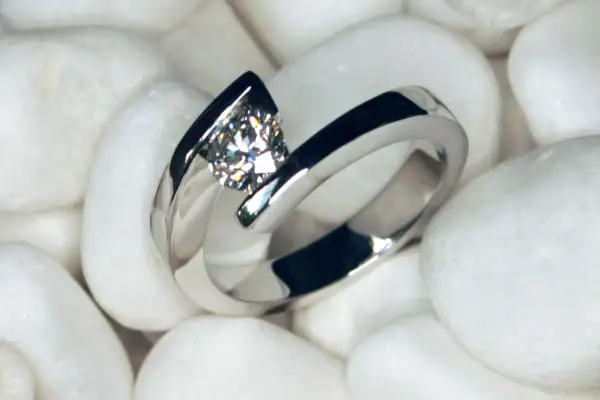 Anillo de oro blanco con diamante, sobre piedras blancas. La joya perfecta para elegir las piedras para anillos de compromiso.