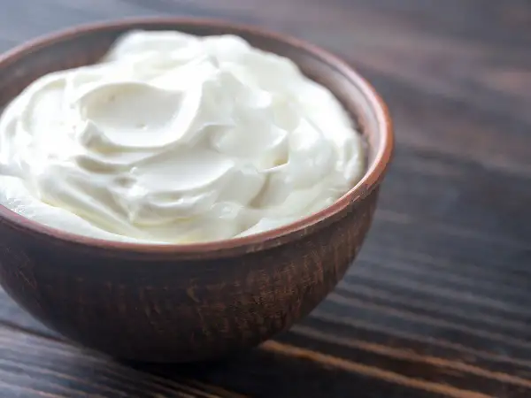 Crème d'Isigny on a wooden table, ready for a delicious crème d'isigny recette.