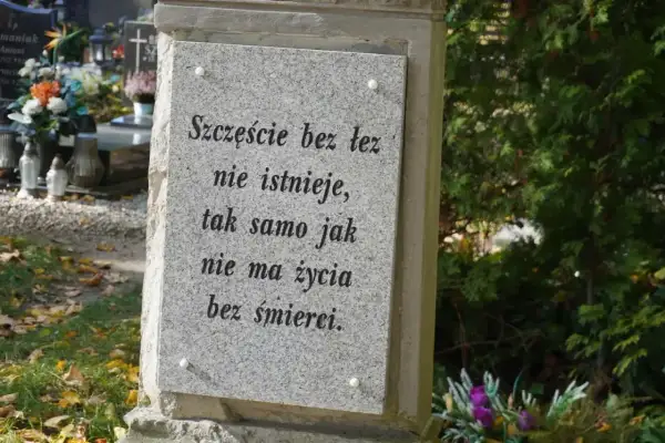 Kamienna płyta na grobie urnowym z napisem "Szczęście bez łez nie istnieje, tak samo jak nie ma życia bez śmierci".