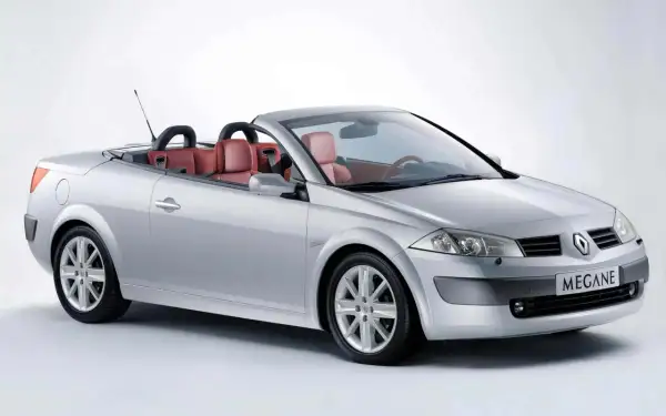 Srebrny Renault Megane cabrio z czerwonymi skórzanymi siedzeniami, gotowy na letnią przejażdżkę.