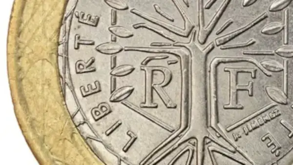 Detalle de una moneda de la República Francesa con un árbol estilizado y las letras "R" y "F".