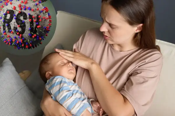 Zmartwiona mama sprawdza gorączkę u niemowlaka. W tle wirus RSV, który może być groźny dla maluchów.