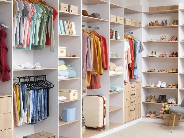 Armarios organizados con ropa colgada, doblada y zapatos en estantes. Un armario funcional para organizar tu ropa.