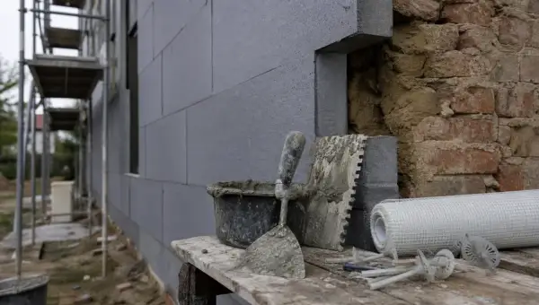 Attrezzi da cantiere e materiali per cappotto termico. Si intravedono mattoni a vista, forse un limite di questo sistema.