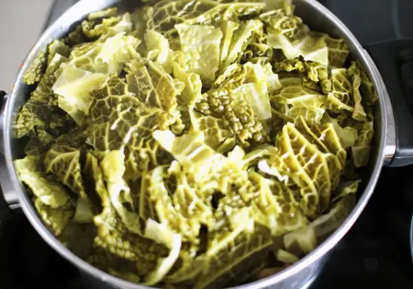 Gotująca się kapusta włoska w garnku, gotowa na pyszne przepisy.