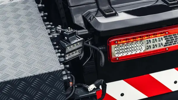 Feu arrière LED d'un véhicule tout-terrain, avec une bande réfléchissante rouge et blanche. Un projecteur auxiliaire est monté à proximité, conforme à la norme IP63.
