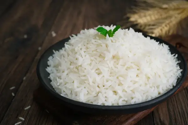 Un piatto di riso basmati, cotto alla perfezione, guarnito con una fogliolina di menta. La cottura ideale per un riso profumato.