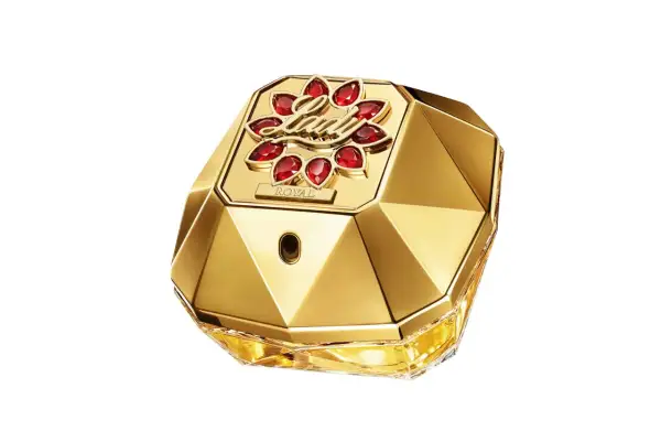 Złoty flakon perfum Paco Rabanne Lady Million Lucky, ozdobiony czerwonymi kamieniami i napisem "ROYAL", emanuje luksusem i szczęściem.