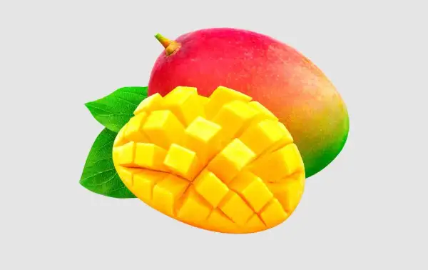 Soczyste mango, pokrojone w kostkę, obok całego owocu. Czy pies może mango? To pytanie nurtuje wielu właścicieli czworonogów.