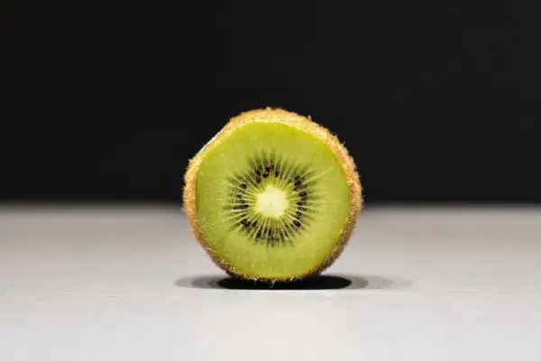 Połówka kiwi, idealna na keto, z widocznymi czarnymi pestkami i zielonym miąższem.