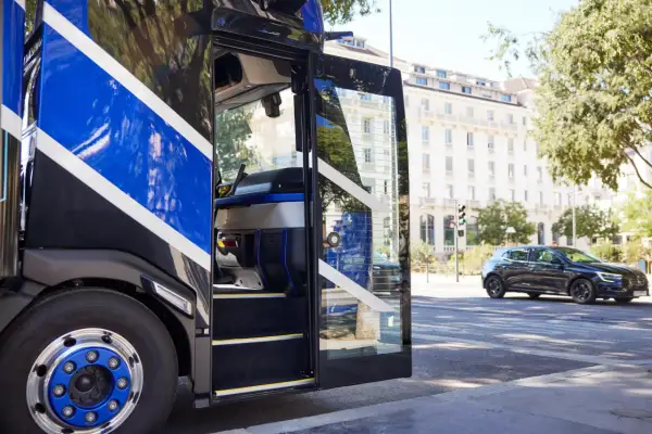 Cabine ouverte d'un camion Renault Trucks, avec des bandes bleues vives. L'air frais de la ville, comme de l'oxygène, circule.