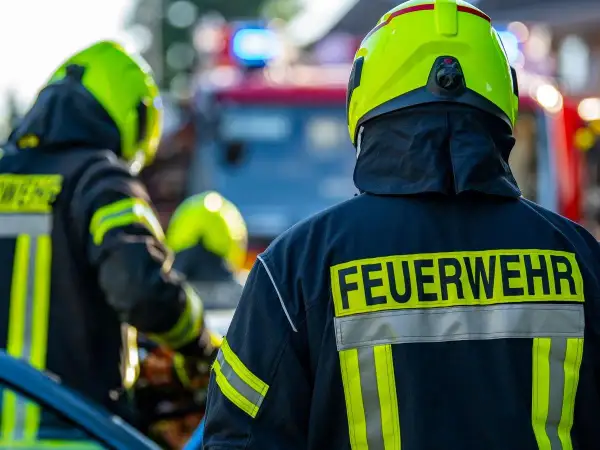 Feuerwehrleute in voller Montur, bereit für den Einsatz. Interessiert, wie viel verdient man als Feuerwehrmann netto?