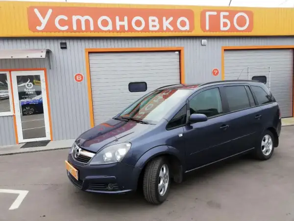 Opel Zafira 1.6 benzyna opinie: rodzinny van przed budynkiem z napisem "Установка ГБО".