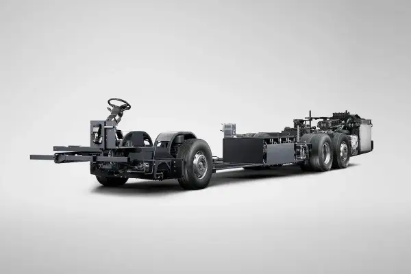 Châssis d'un bus Scania hybride, prêt à être assemblé, avec son volant et ses roues visibles.