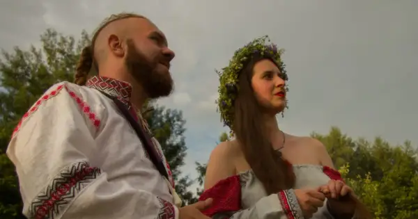 Para młoda w tradycyjnych strojach, symbolizująca żywą wiarę i tradycję przekazywaną w rodzinie.