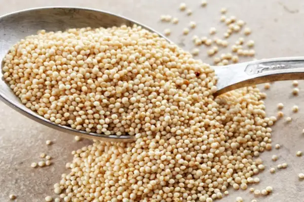 Ein Löffel voller gepuffter Amaranth-Samen, die leicht und luftig aussehen. Sie sind eine gesunde Zutat, die man in Müsli oder als Snack genießen kann.