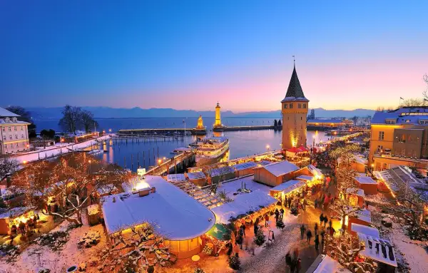 Winterzauber am Hafenweihnacht Lindau: Lichterglanz, Schnee und Menschenmassen vor dem alten Wasserturm und den Leuchttürmen.