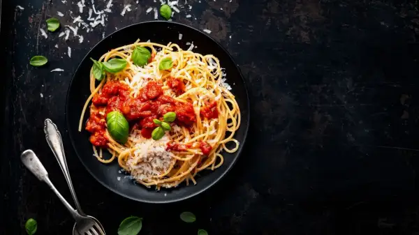 Ein Teller Spaghetti mit Tomatensauce, Parmesan und Basilikum. Perfekt für vegetarische italienische Pasta Rezepte.