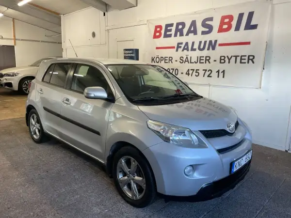 Silver Toyota Urban Cruiser, möjligen med ett mindre problem, står parkerad framför en bilfirma i Falun.