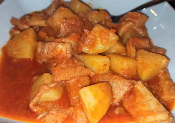 Un saporito piatto di trippa con patate, cotto in un ricco sugo di pomodoro.
