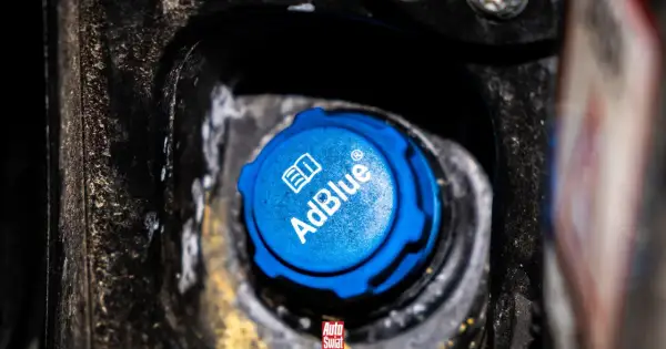 Niebieski korek wlewu AdBlue, z napisem "AdBlue" i symbolem książki. Czy adblue zamarza? To pytanie nurtuje wielu kierowców zimą.