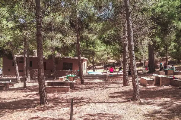 Un día de campo en Enix, con mesas de piedra y gente disfrutando del bosque. ¡Mucho que ver y hacer!