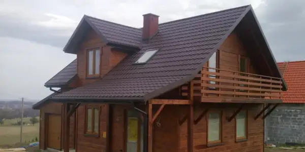 Drewniany dom pod klucz, gotowy do zamieszkania. Piękna, brązowa dachówka i przestronny balkon.