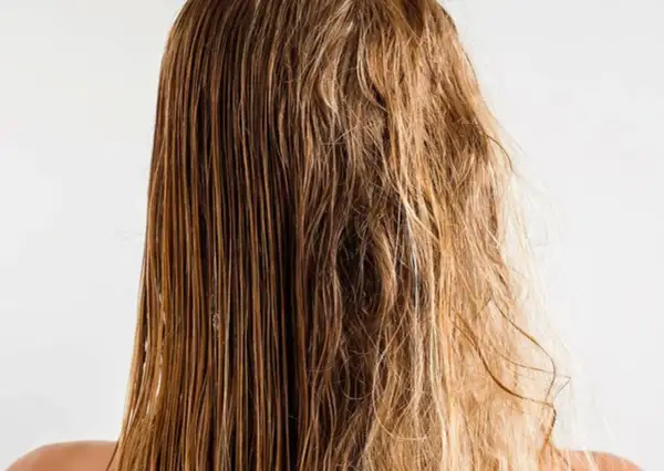 Cabello mojado y liso a un lado, y pelo roto y encrespado al otro, mostrando el contraste.