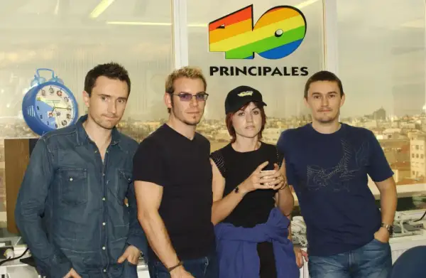 The Cranberries, marząc o sukcesie, pozują przed logo 40 Principales.
