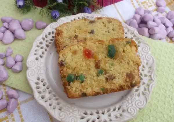 Keks stary przepis, z bakaliami i kandyzowanymi owocami, na ozdobnym talerzyku.