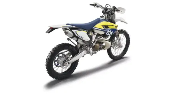 Husqvarna TE 250 gotowy do jazdy po bezdrożach. Biało-żółty motocykl terenowy z niebieskim siedzeniem.