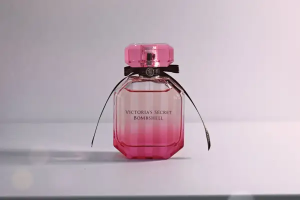 Różowa butelka kultowych perfum damskich Victoria's Secret Bombshell z czarną wstążką.