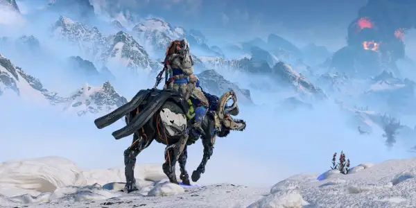 Aloy na mechanicznym koniu przemierza śnieżne góry. W oddali widać wybuch wulkanu, zapowiadający zagrożenie w Horizon 3 Nemesis.