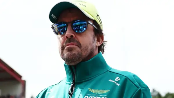 Alonso hoy, con gafas de sol reflejando el paddock, viste un polo verde de Aston Martin.