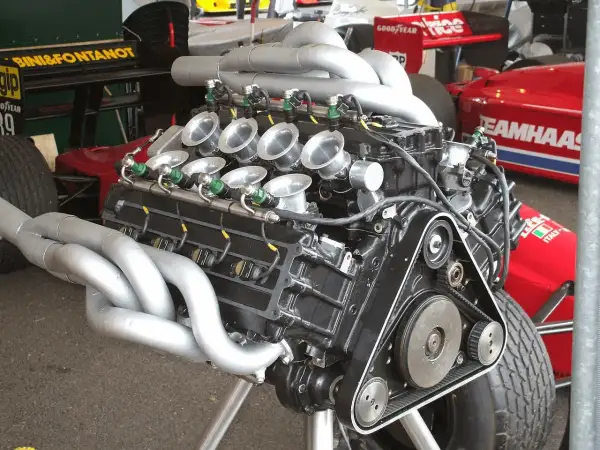 Motor V8 de F1 con colectores de escape plateados y trompetas de admisión. Un motor potente listo para la carrera.