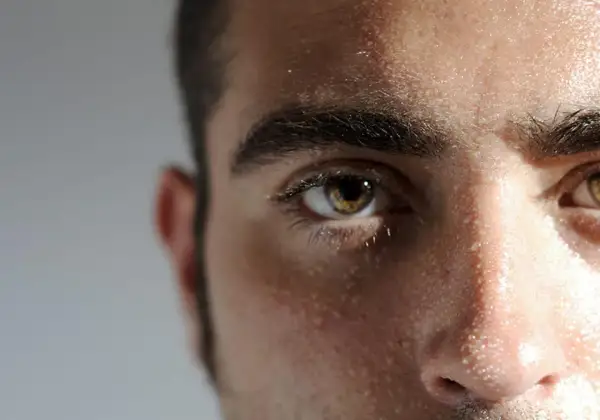 Gouttes de sueur sur le front, gras, homme concentré, regard intense.
