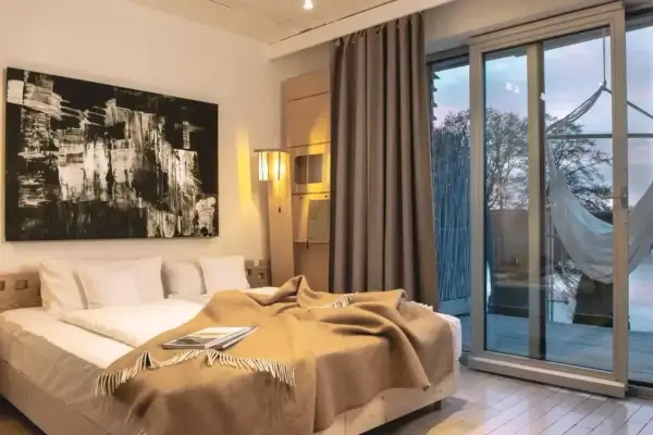 Przytulny pokój w hotelu butikowym. Co to jest? To miejsce z wygodnym łóżkiem, sztuką i widokiem na naturę.