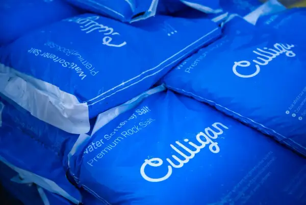 Pile de sacs bleus Culligan de sel pour adoucisseur d'eau. Difficile de dire combien de sac de sel pour adoucisseur il y a au total.
