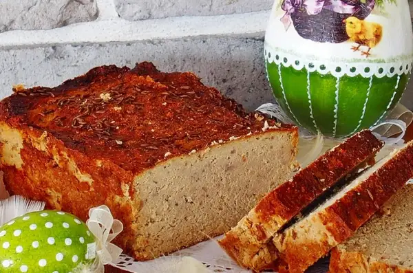 Pyszny pasztet drobiowo-wieprzowy z wątróbką, idealny na wielkanocny stół, obok ozdobnych jajek.