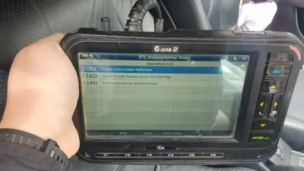 Escáner G-SCAN 2 muestra código C1201, fallo en sistema de control de motor de un Toyota.