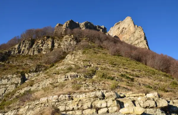 Vue spectaculaire des 3 becs, falaises rocheuses et arbres dénudés sous un ciel bleu intense.