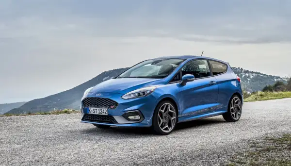 Niebieski Ford Fiesta ST na górskiej drodze, gotowy na każdą przygodę.