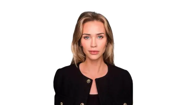 Isabella Jedler, en kvinna med blont hår och blå ögon, bär en svart kavaj med gulddetaljer.